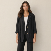A model wearing a loose-fitting black women's blazer, front view