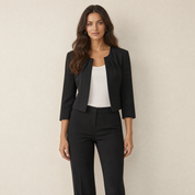 A model wearing a cropped black women's blazer with three-quarter sleeves, front view