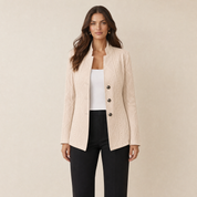 A model wearing a textured beige women's blazer with a stand collar, front view