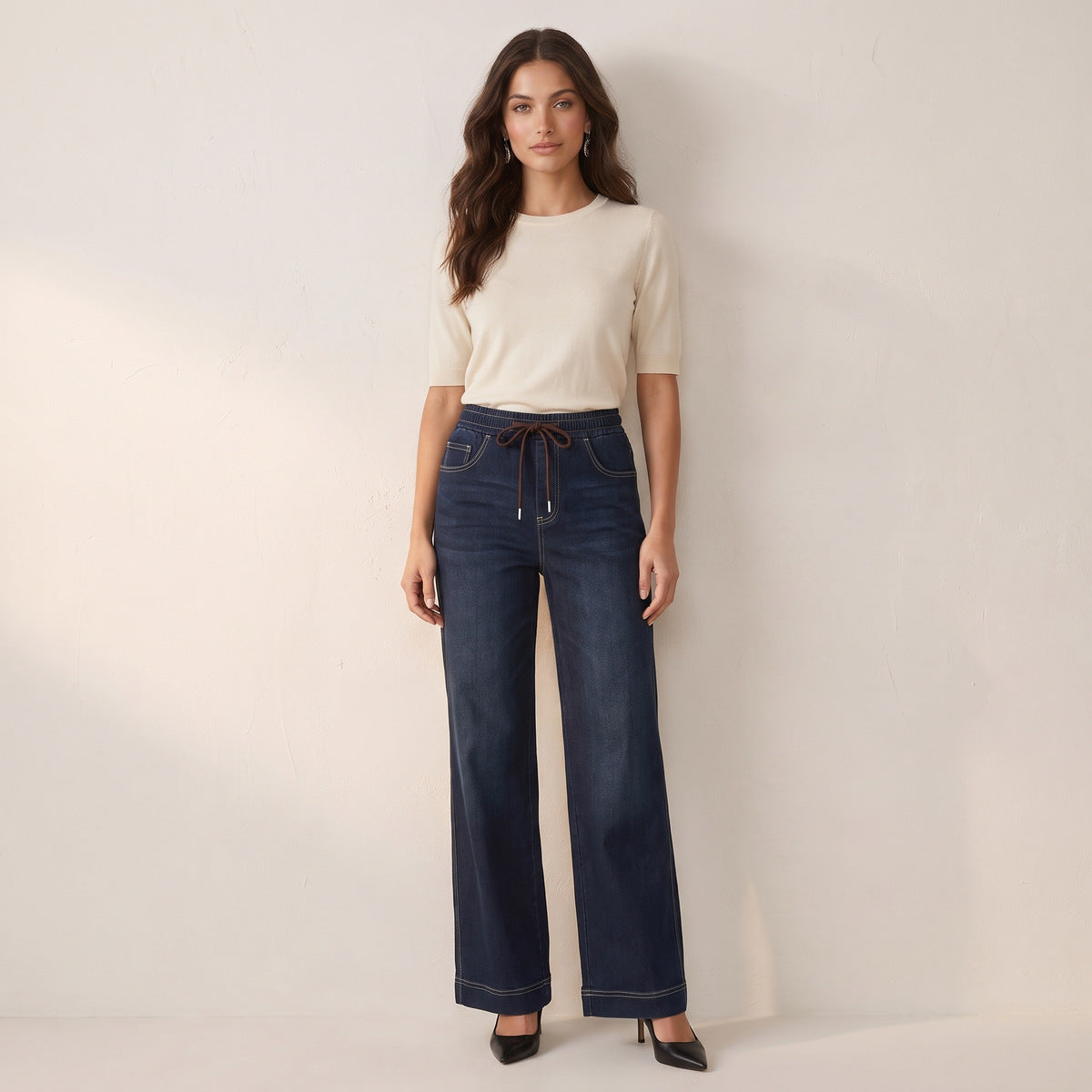 Model wearing women's dark wash wide leg jeans with drawstring waist, full length front view
