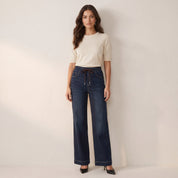 Model wearing women's dark wash wide leg jeans with drawstring waist, full length front view