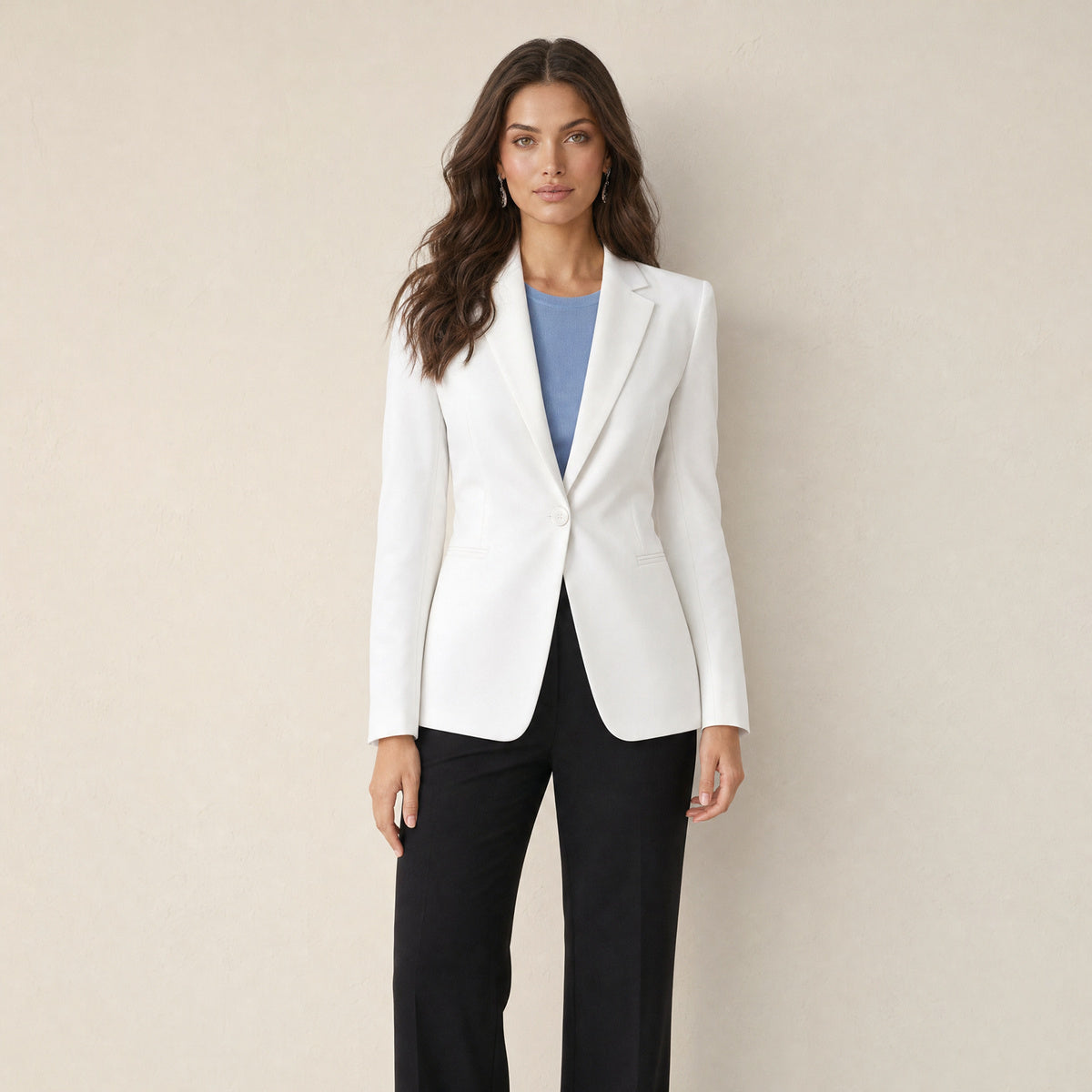 Model in witte getailleerde damesblazer met klassieke revers en één knoop, vooraanzicht